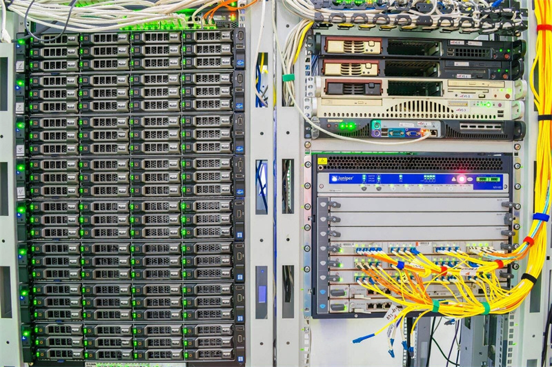 Data center server rack with network cables and blinking LED lights.